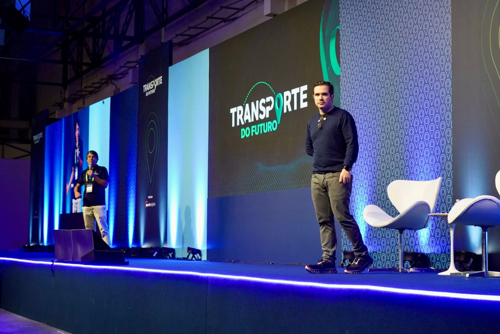 Palestrante no palco com o logo Transporte do Futuro ao fundo